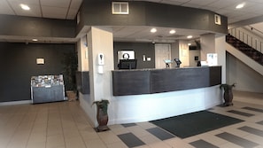 A reception area with a counter, a computer, a phone, and a plant. - Quality Inn near Potomac Mills (Woodbridge)
