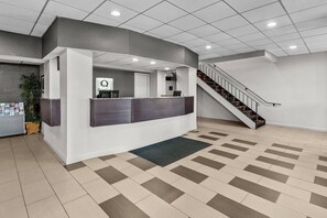 A reception area with a counter, a staircase, and a patterned floor.