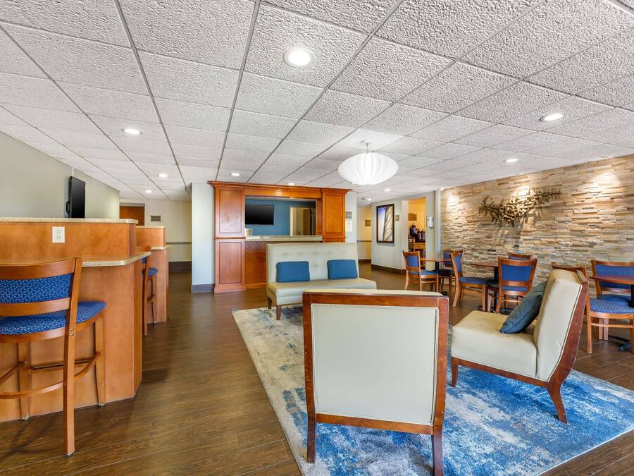 A spacious lobby with a reception desk, seating area, and a stone accent wall.