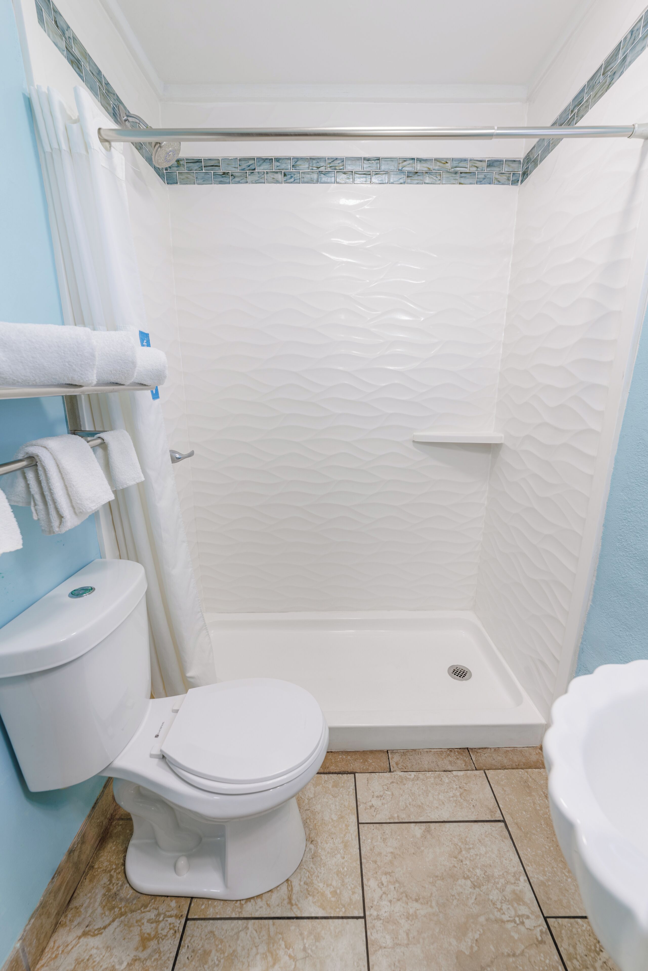 A bathroom with a shower, toilet, and bathtub.