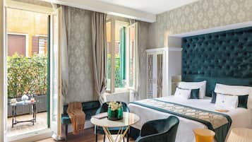A hotel room with a large bed, a small table, a chair, and a view of the outside.