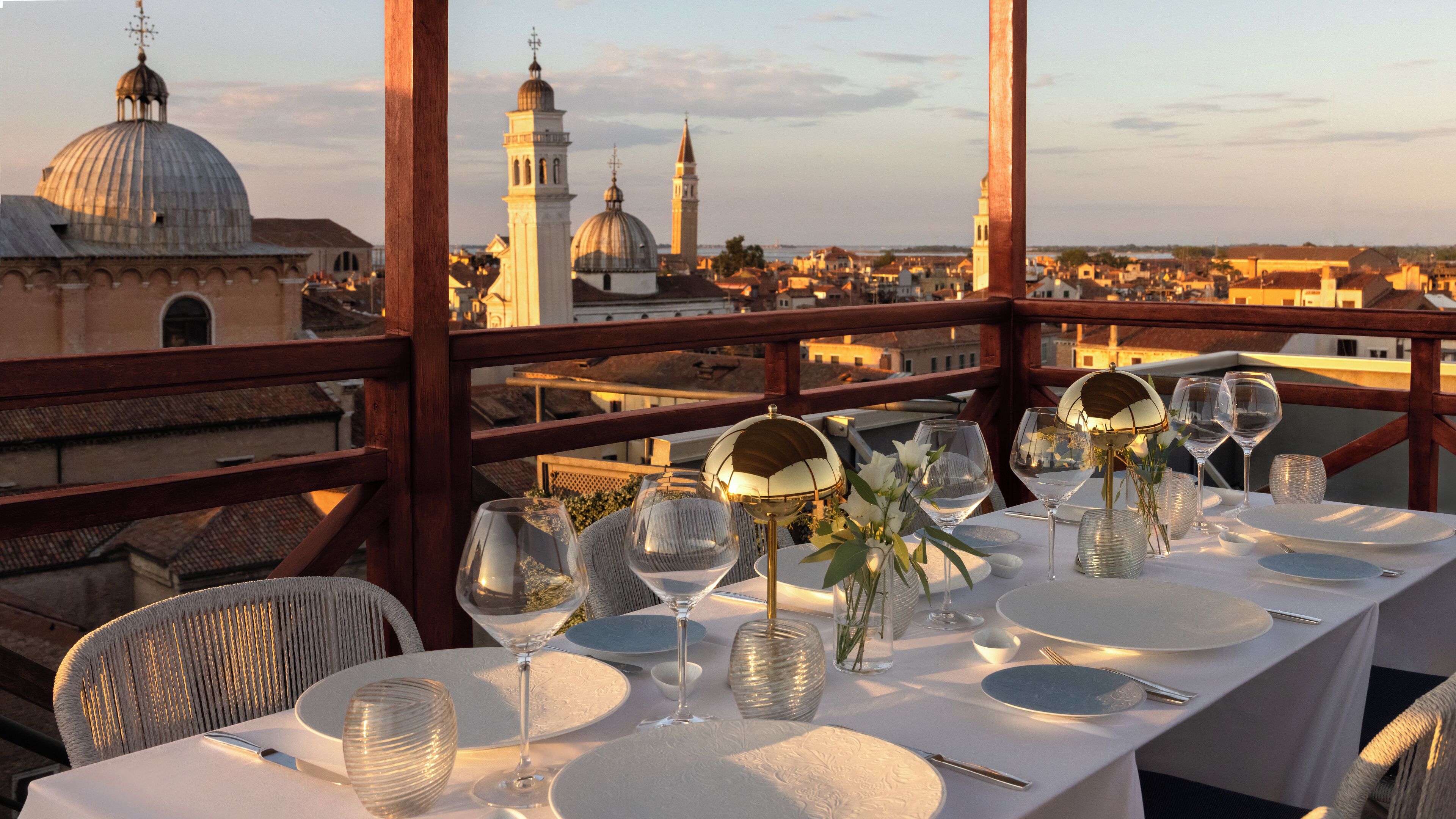 Una mesa lista para comer con vistas a edificios históricos y cúpulas.
