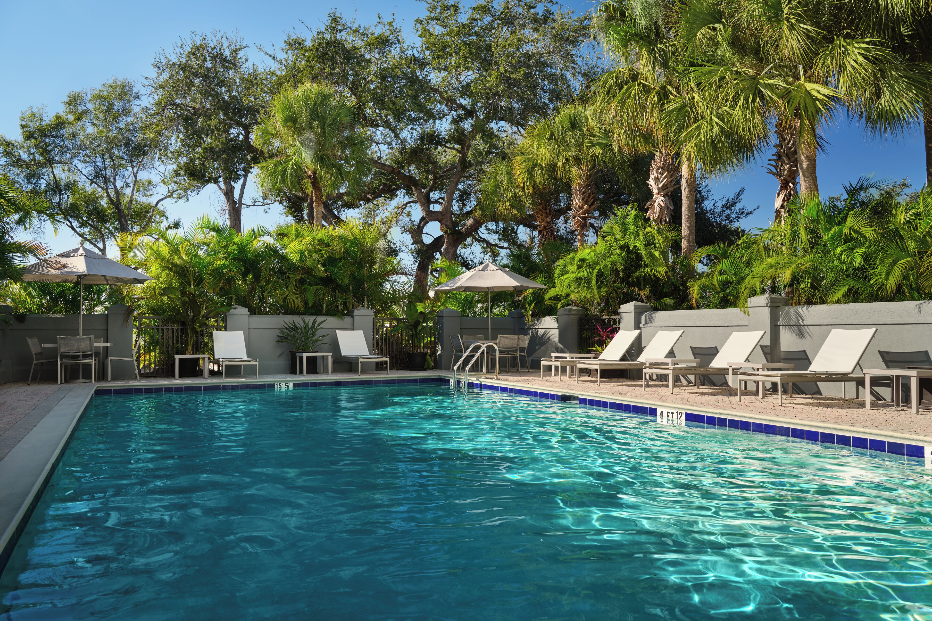Una piscina al aire libre, sillones reclinables de piscina