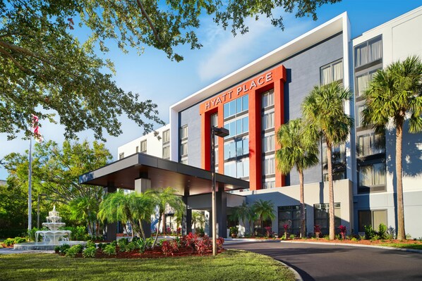 A modern hotel with a prominent 'Hyatt Place' sign, a covered entrance, and a landscaped garden with a fountain. - Hyatt Place Tampa Airport/Westshore (Tampa)