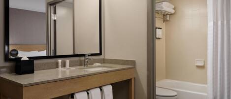 A bathroom with a sink, mirror, and toilet.