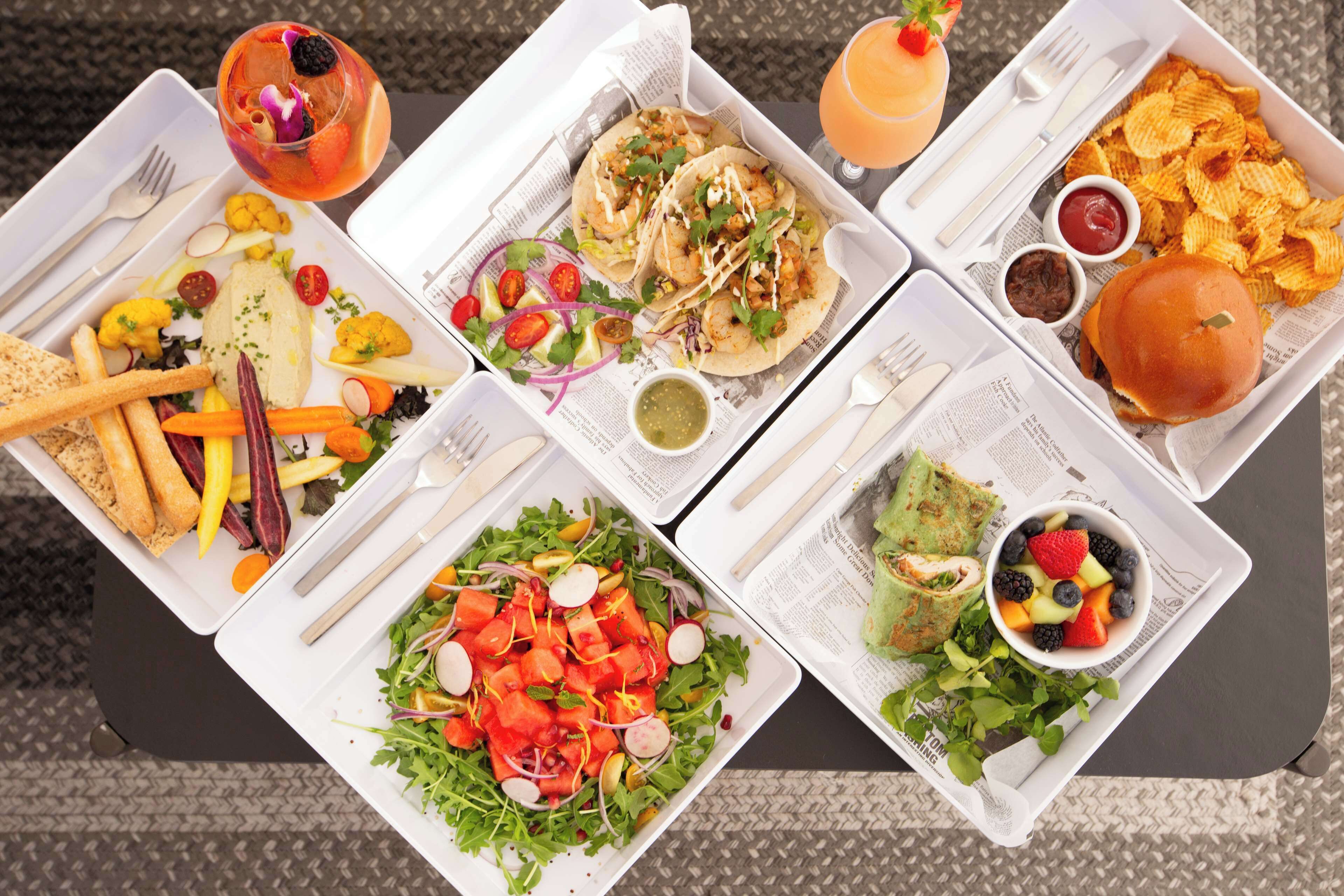 A table with various food items including tacos, a burger, fries, and a salad.