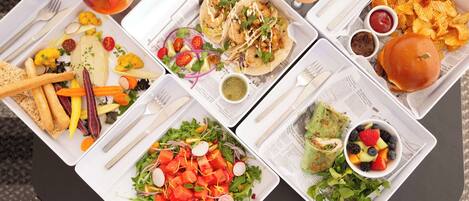 A table with various food items including tacos, a burger, fries, and a salad.