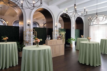A spacious lobby with a white sofa, a wooden coffee table, and a chandelier. at Mills House Charleston, Curio Collection by Hilton