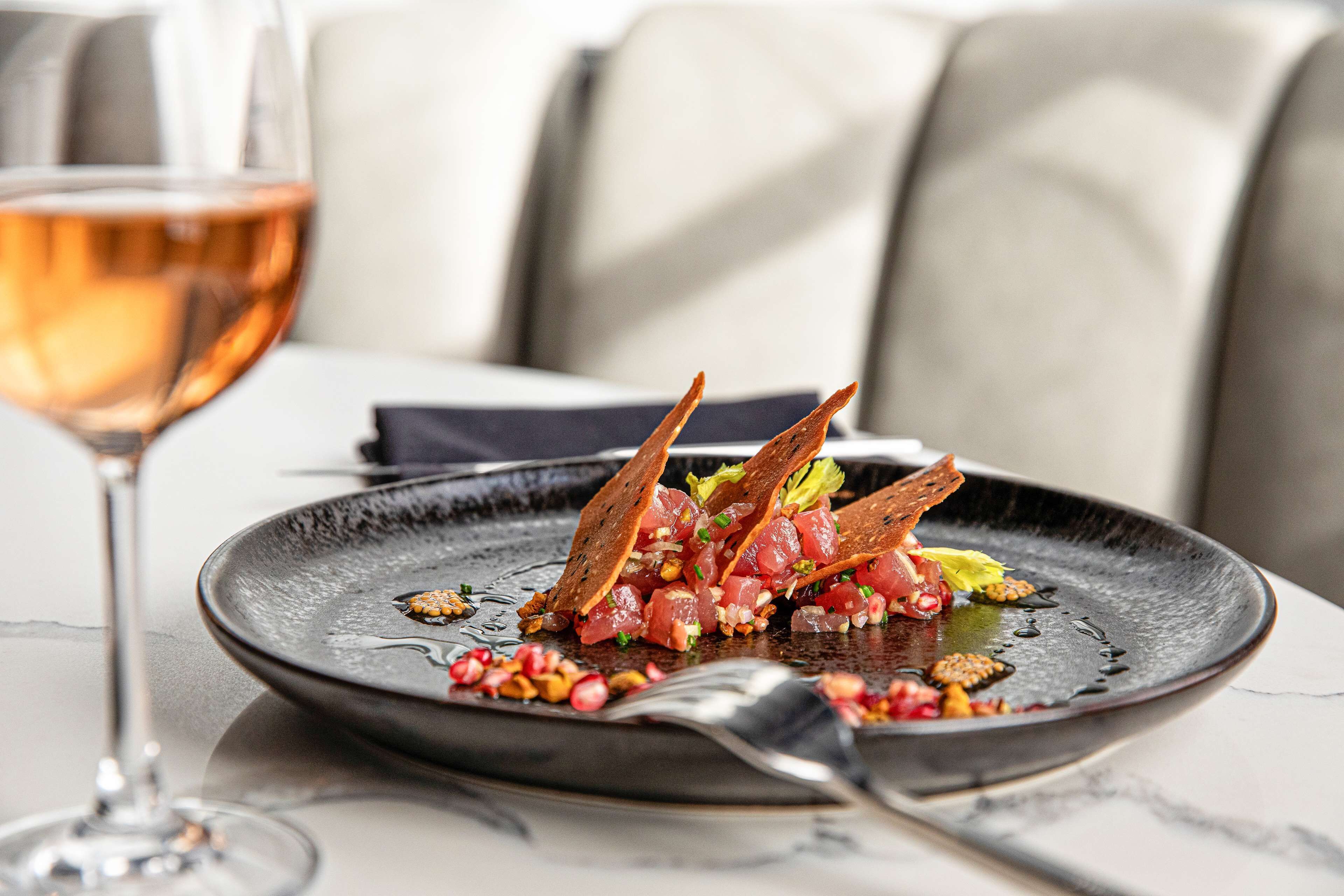 A plate of food with a glass of wine on a table.