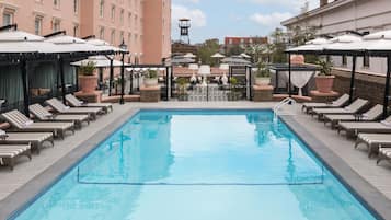 Una piscina al aire libre, sillones reclinables de piscina
