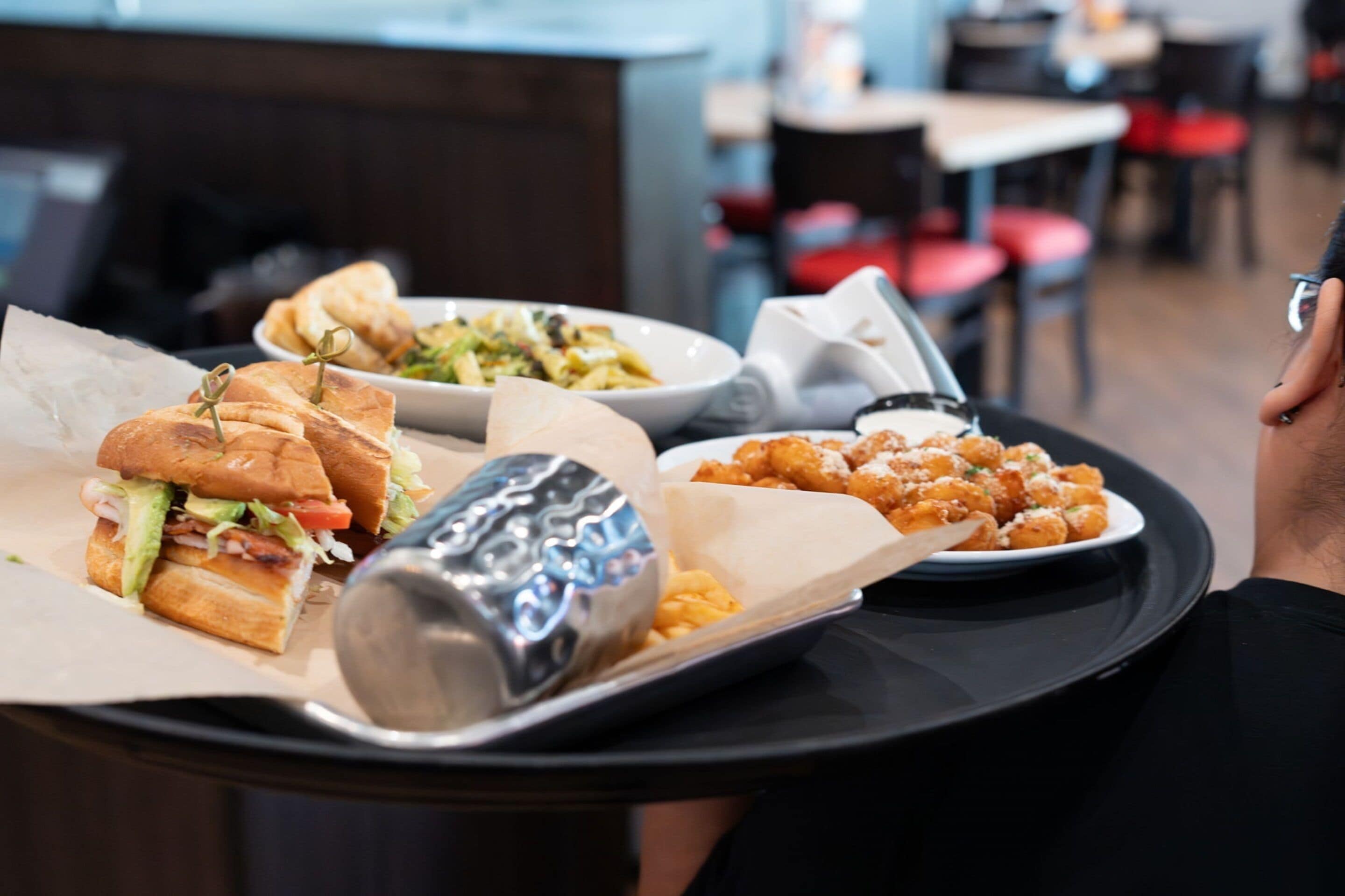 A tray with a sandwich, a salad, and fried chicken wings.