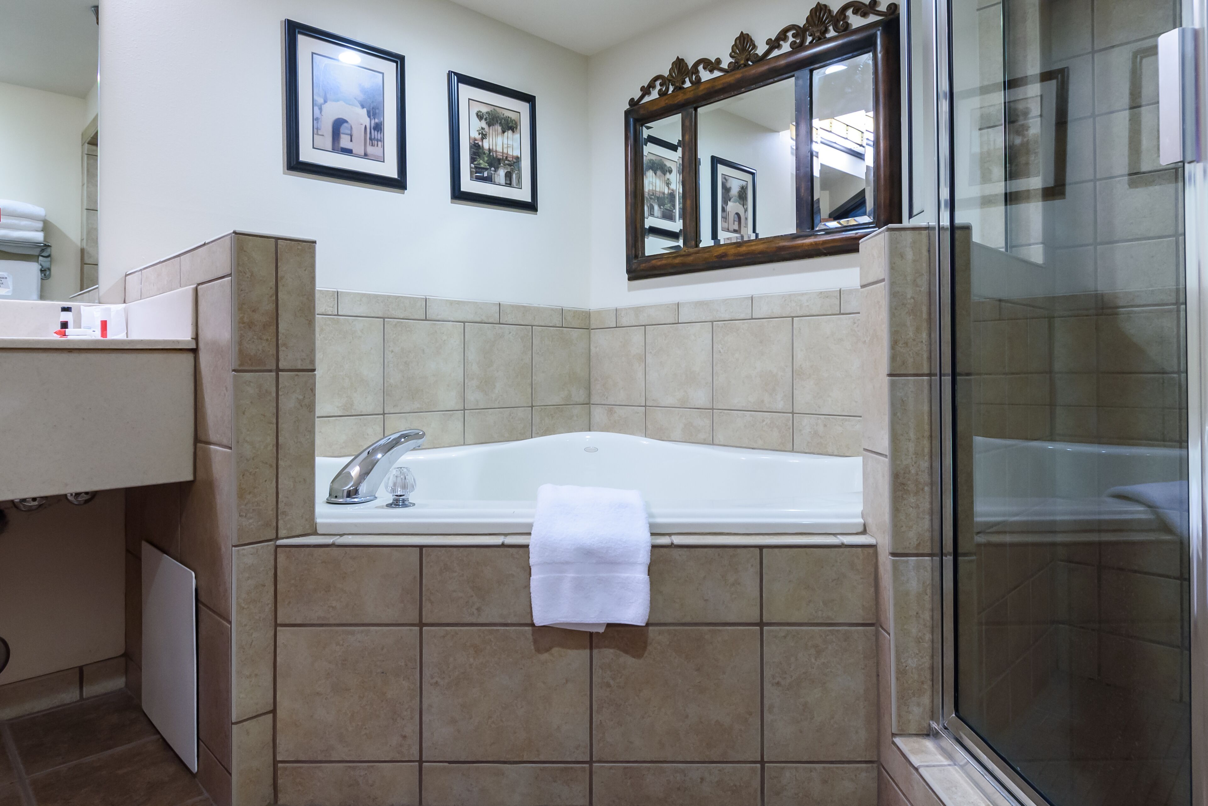 Un baño con bañera, ducha y tocador con espejo.