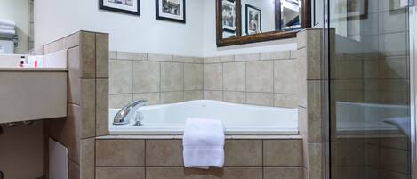 Un baño con bañera, ducha y tocador con espejo.