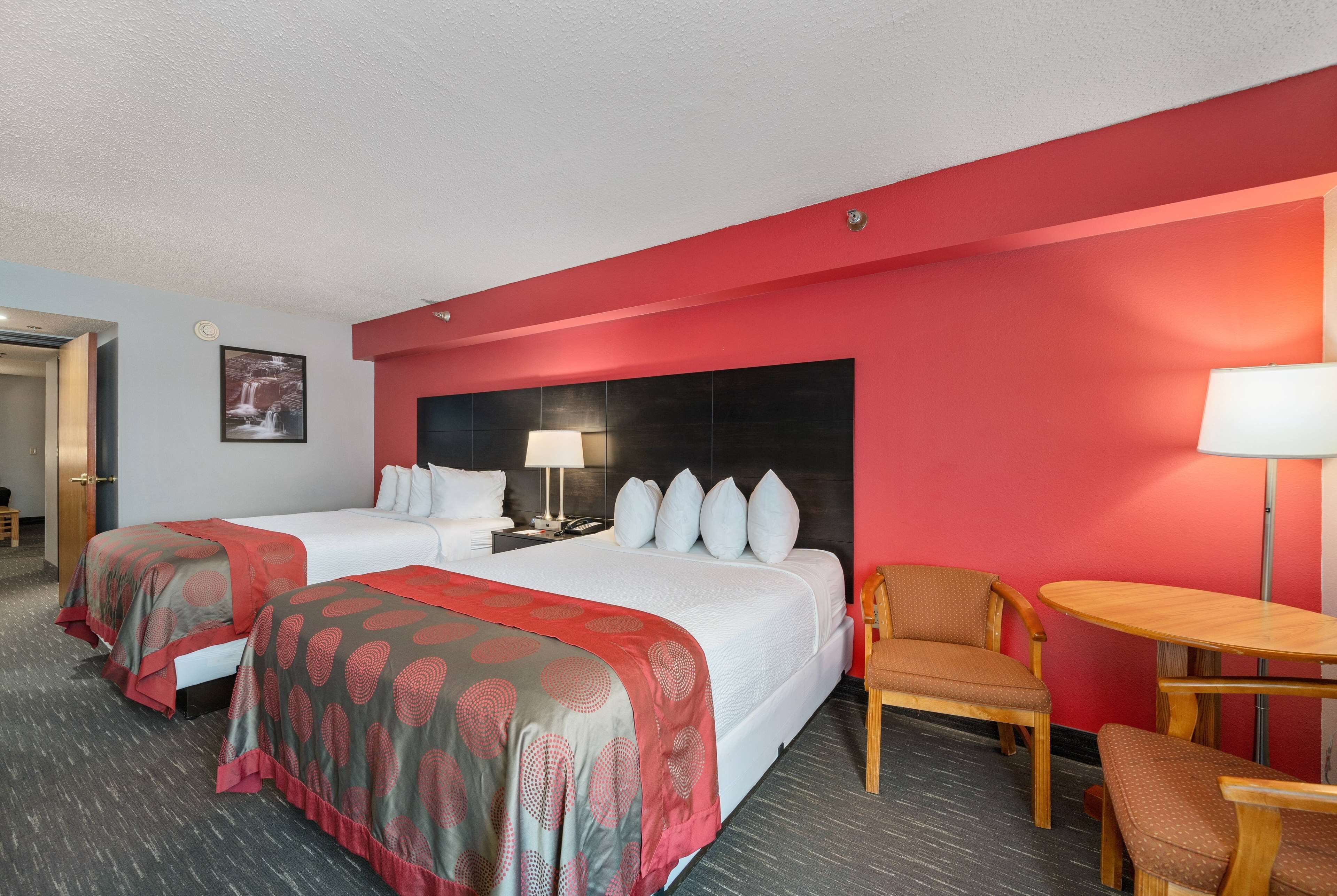 Une chambre d’hôtel avec deux lits, un bureau et une chaise.