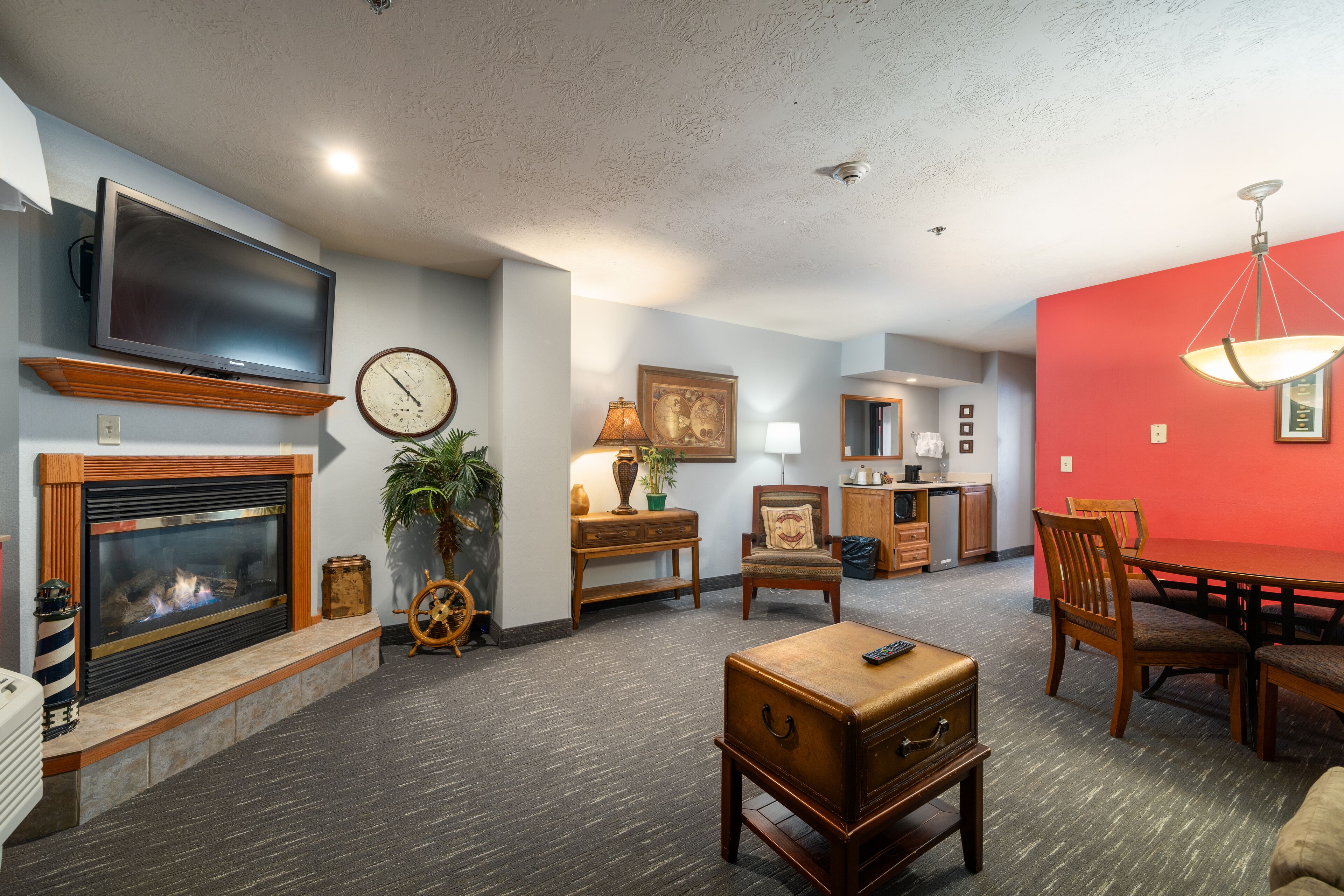 A living room with a fireplace, television, dining table, and chairs.