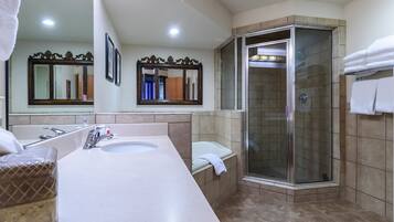 Un baño con un espejo grande, un lavabo, una bañera y una ducha con mampara de vidrio.