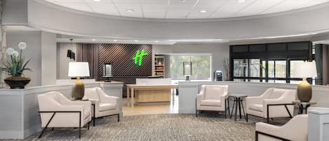 A spacious lobby with a reception desk, seating area, and a patterned carpet.