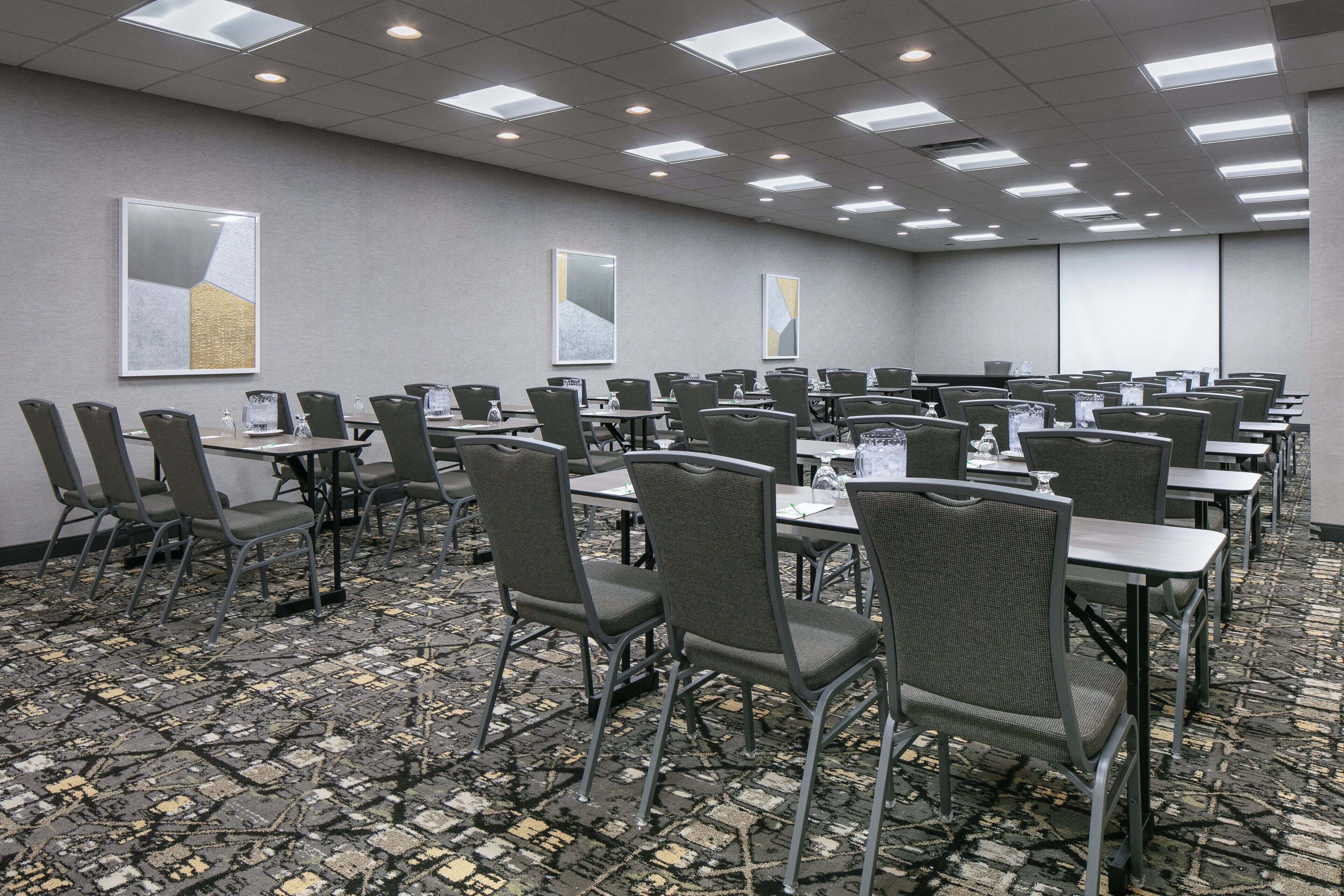 Una sala conferenze con diversi tavoli e sedie, dotata di bottigliette d'acqua e cartellini con i nomi.