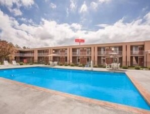 A hotel with a swimming pool, multiple balconies, and a clear sky. - Ramada by Wyndham Wytheville (Wytheville)