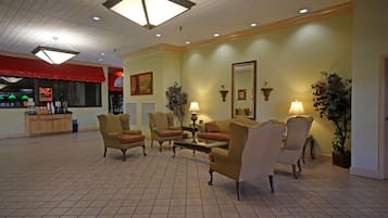 A spacious lobby with multiple seating areas, a reception desk, and decorative wall art.