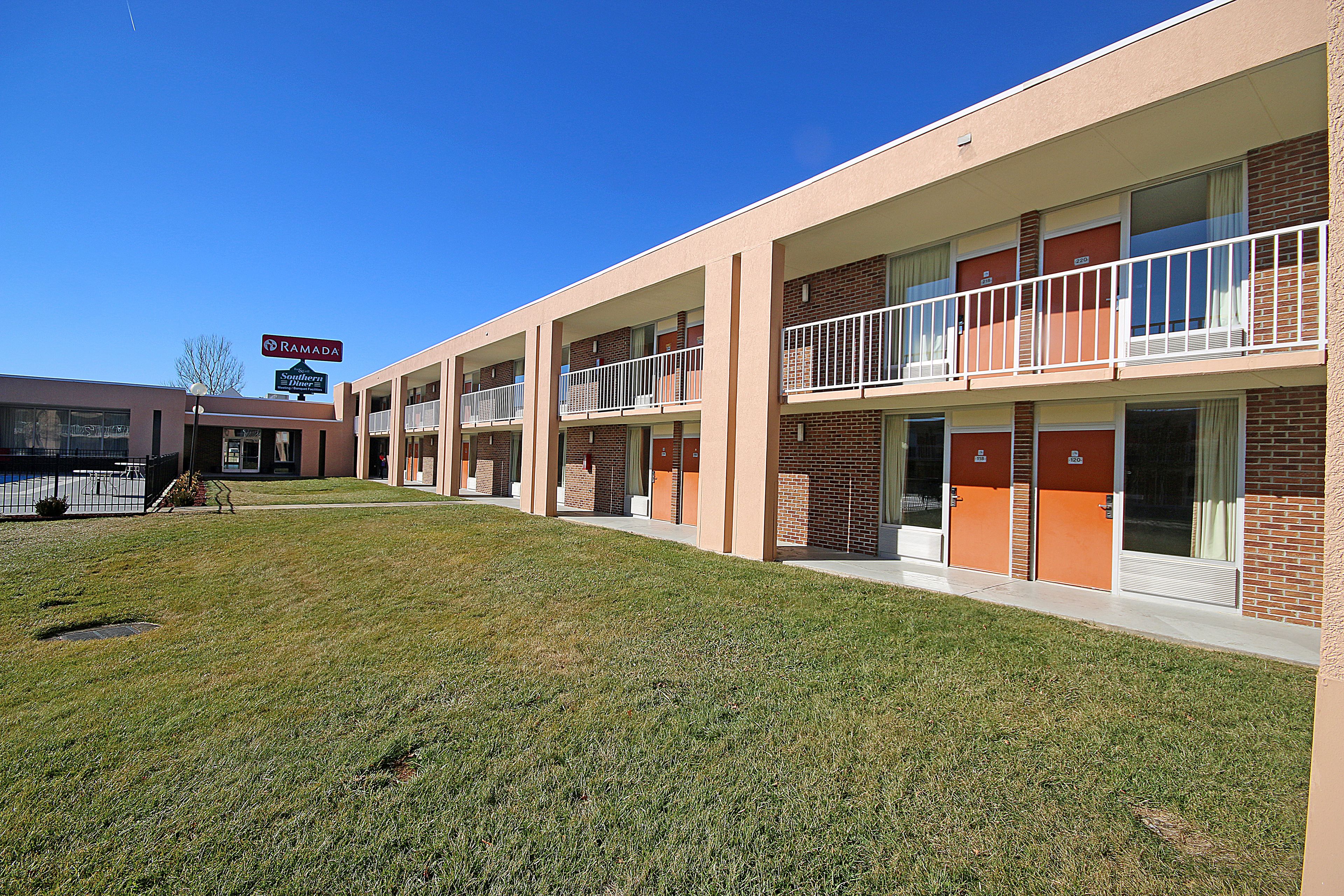 A multi-story motel with a flat roof, brick exterior, and a sign indicating it is a Ramada motel.