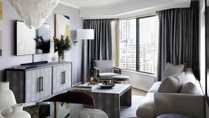 A modern living room with a glass dining table, grey sofa, and a large window with curtains. - Pullman Sydney Hyde Park (Darlinghurst)