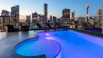 Una piscina al aire libre, sillones reclinables de piscina