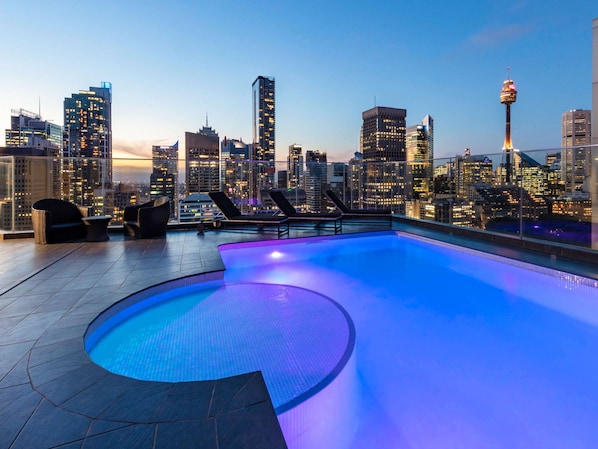 Una piscina al aire libre, tumbonas