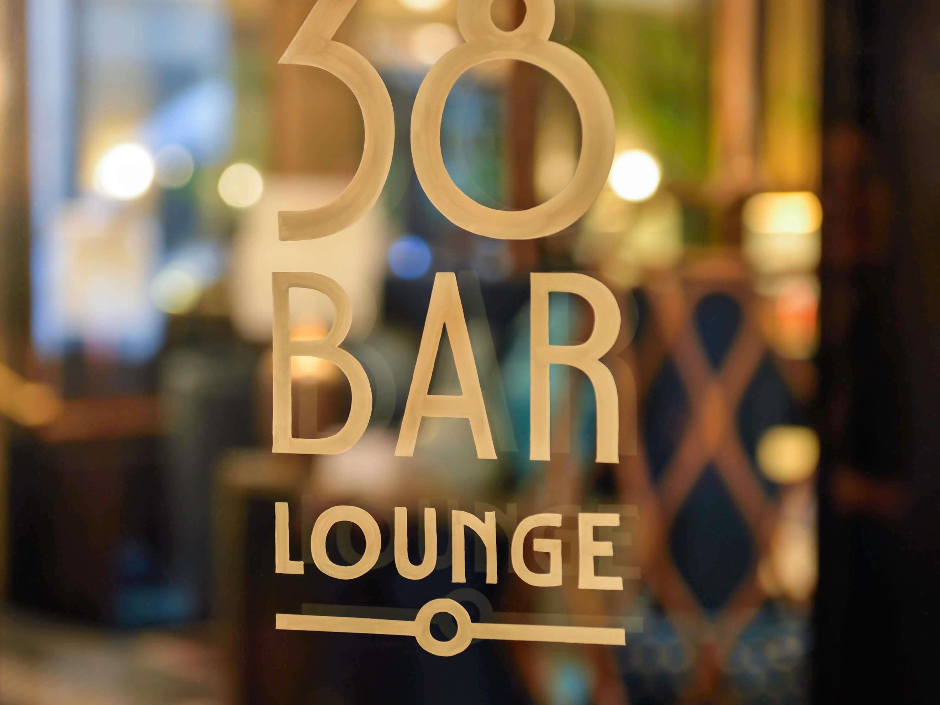 A sign for '38 BAR LOUNGE' with a blurred background.