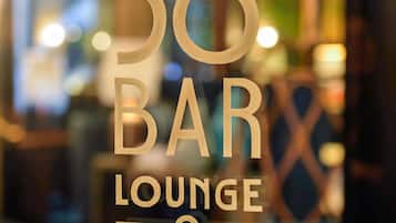A sign for '38 BAR LOUNGE' with a blurred background.