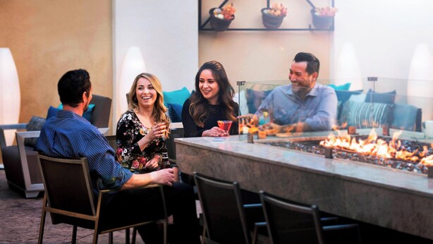 Un gruppo di persone sedute attorno a un'area bar con un elemento decorativo a camino.