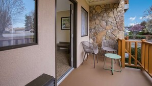 A balcony with a stone wall, two chairs, and a small table. - Best Western Milton Inn (Blairsville)
