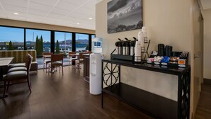 A hotel lobby with a reception desk, seating area, and large windows offering a view of the cityscape. - Best Western Milton Inn (Blairsville)