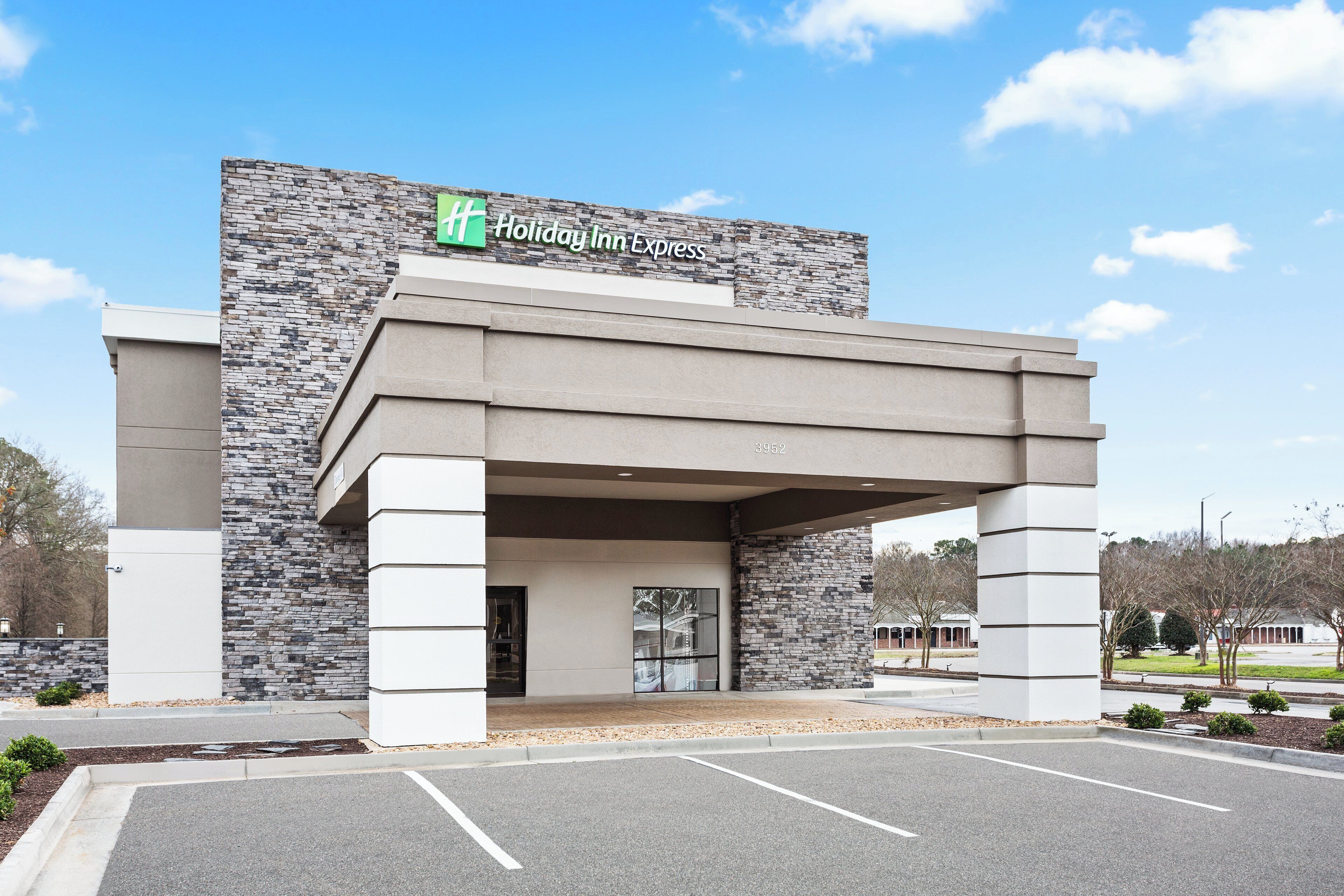 A Holiday Inn Express building with a stone facade and a flat roof entrance.