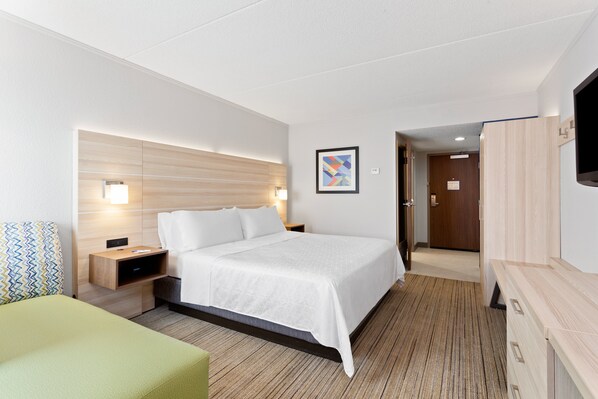 A hotel room with a bed, bedside tables, a TV, and a door leading to a hallway. - Holiday Inn Express Hopewell - Fort Lee by IHG (Hopewell)
