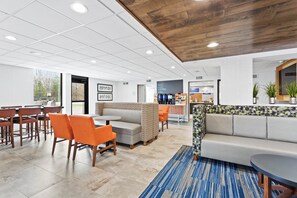 A modern interior with a seating area, a coffee station, and a bakery section. - Holiday Inn Express Hopewell - Fort Lee by IHG (Hopewell)