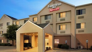 Un hotel Fairfield Inn Marriott con entrada cubierta y zona de estacionamiento con señalización de accesibilidad para personas con discapacidad.