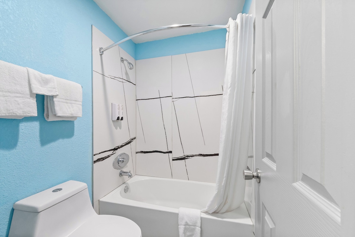 A bathroom with a bathtub, shower, and toilet.