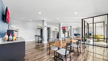 Eine moderne Hotelhalle mit einer Rezeption, einer Sitzecke und Blick auf die Stadt durch große Fenster.