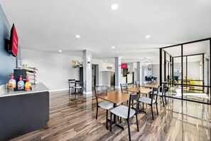Un moderno vestíbulo de hotel con mostrador de recepción, zona de estar y vistas a la ciudad a través de amplios ventanales.