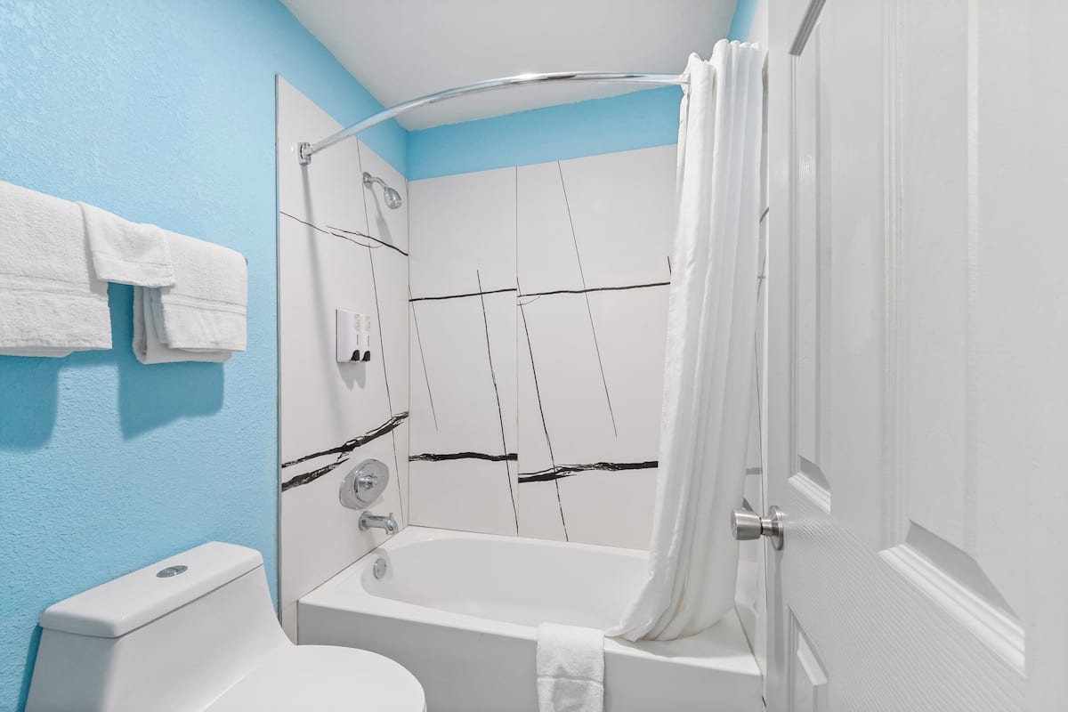 Un baño con bañera, ducha e inodoro.