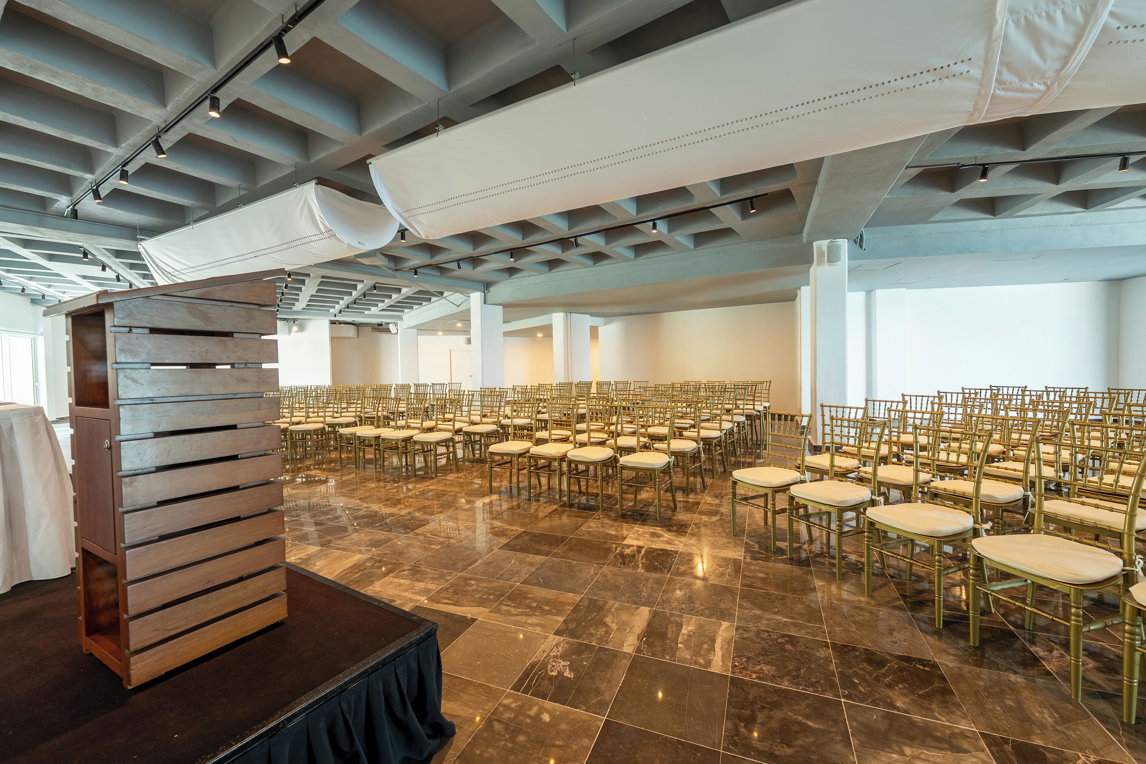 A spacious hall with rows of chairs and a stage area.