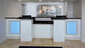 A modern kitchen with a central island, white cabinetry, and a backsplash with the Holiday Inn Express logo. - Holiday Inn Express Lynchburg by IHG (Lynchburg)