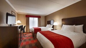 A hotel room with two beds, a desk with a computer, a TV, and a window with curtains. - Best Western Springfield West Inn (West Springfield)