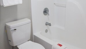 Une salle de bain équipée de toilettes, d’une baignoire et d’une douche.