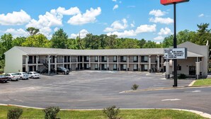 Un motel avec une enseigne indiquant « Econo Lodge Inn & Suites » et un panneau d’accueil énumérant les services proposés.