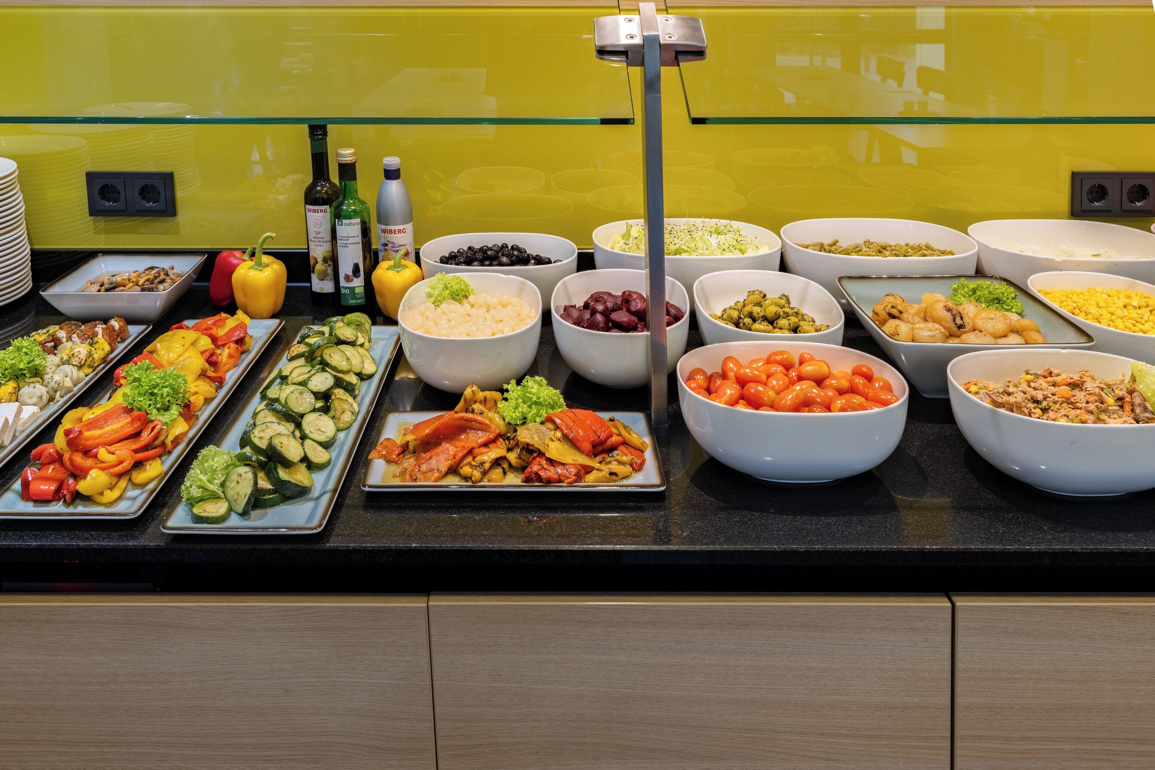 Een buffet met diverse gerechten, waaronder groenten, fruit en zeevruchten.