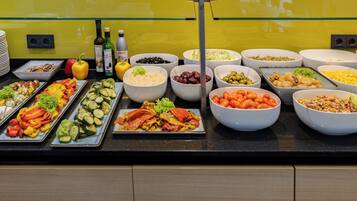 Een buffet met diverse gerechten, waaronder groenten, fruit en zeevruchten.