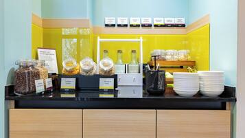 A breakfast buffet with labeled food items and a coffee station.