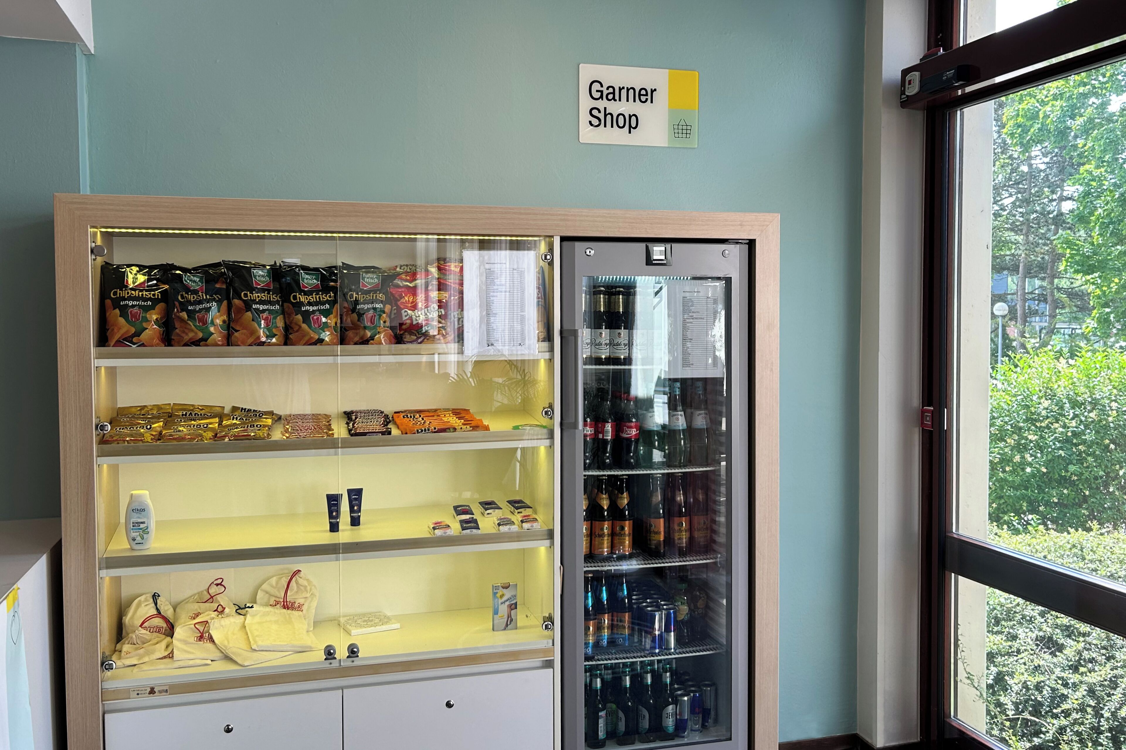 A display case with snacks and beverages, a sign for 'Garner Shop', and a refrigerated display.